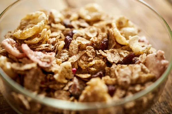 Close-up em uma tigela de café da manhã saudável cheia de granola orgânica em uma mesa de madeira — Fotografia de Stock