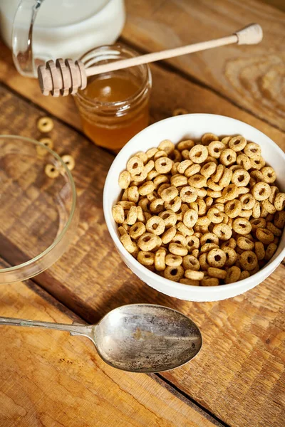 Ciotola sana per la colazione mattutina piena di fiocchi di miele con zuppa di miele e latte su un tavolo di legno — Foto Stock