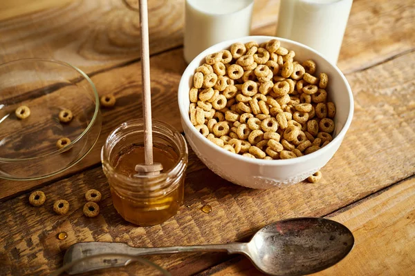 Ciotola sana per la colazione mattutina piena di scaglie di miele con zuppa di miele e latte sul tavolo di legno — Foto Stock