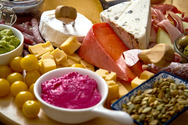 Antipasti deska z różnych przekąsek ser i mięso z hummus i oliwki na desce — Zdjęcie stockowe