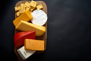 Siyah tablo peynir çeşitleri ile ahşap tahta