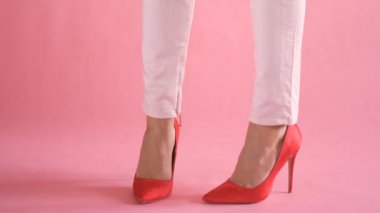 Kadınsı ve zarif yürüyüş sırasında pantolon mercan arka planda ince kadın bacaklar
