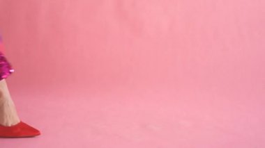 kadınsı ve zarif yürüyüş sırasında çanta ile mercan arka planda kadın bacaklar