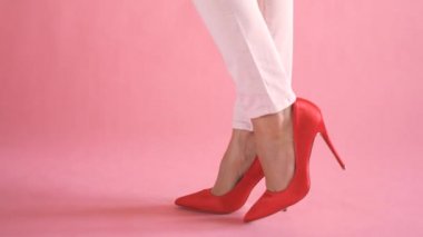 Kadınsı ve zarif yürüyüş sırasında pantolon mercan arka planda ince kadın bacaklar