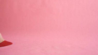 Kadınsı ve zarif yürüyüş sırasında pantolon mercan arka planda ince kadın bacaklar