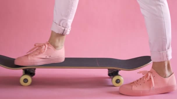 Konec dívkých nohou s skateboard začíná jezdit na korálovém pozadí — Stock video