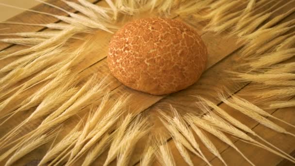 Golden zelfgemaakte Maïsbrood en oren van rogge op houten tafel — Stockvideo