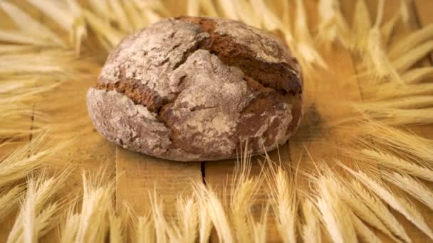 Mörkt hembakat bröd med solrosfrön och rågöron på trä bord — Stockvideo