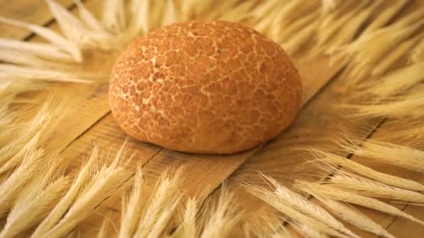 Golden homemade corn bread and ears of rye on wooden table — Stock Video