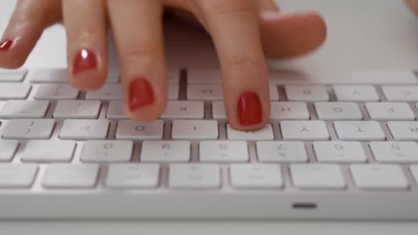Закрытие женских рук, печатающих на клавиатуре белого компьютера — стоковое видео
