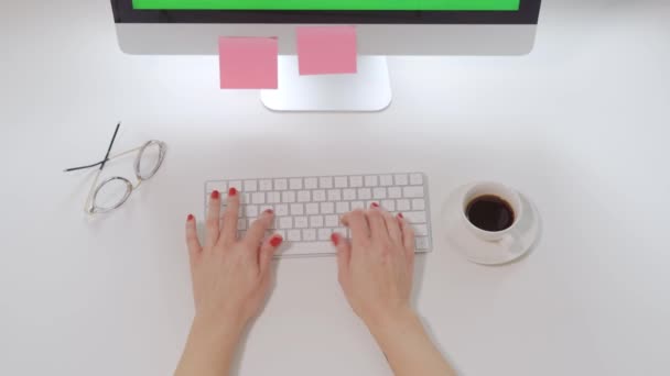 Vista superior en el escritorio blanco de la oficina y el teclado de la computadora y las manos femeninas con clavos rojos escribiendo en él — Vídeos de Stock