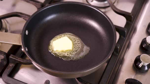 View of the melting butter in pan on gas stove in home kitchen — Stock Video