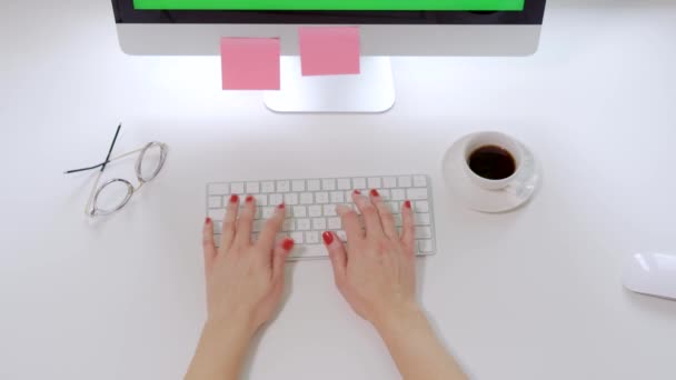 Visão superior na mesa do escritório branco e teclado do computador e mãos femininas com unhas vermelhas digitando nele — Vídeo de Stock