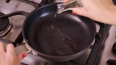 kadın dökülen ve petrol gaz sobası ayakta tava içine cam şişeden ısıtır