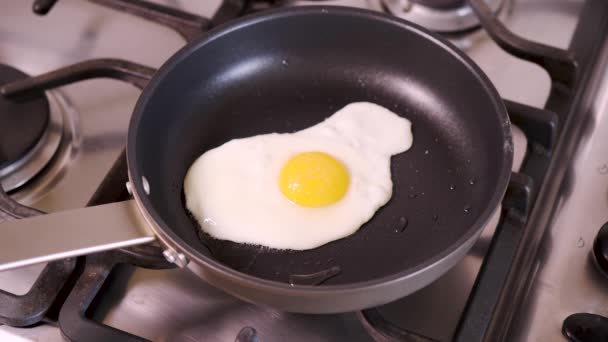 Frau in Hausküche frittiert Spiegelei in Pfanne zum Frühstück auf Gasherd — Stockvideo