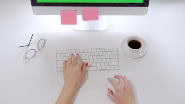 Vista superior en el escritorio blanco de la oficina y el teclado de la computadora y las manos femeninas con clavos rojos escribiendo en él — Vídeo de stock