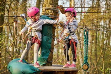 Ormanda bir ip parkta kask iki sevimli küçük kız