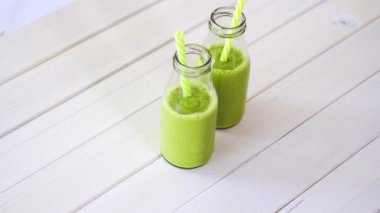 beyaz ahşap masa üzerinde sağlıklı yeşil meyve ve vegan kokteyller