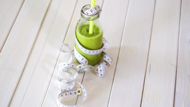 Gezonde groene en veganistische cocktail met centimeter tape op witte houten tafel — Stockvideo