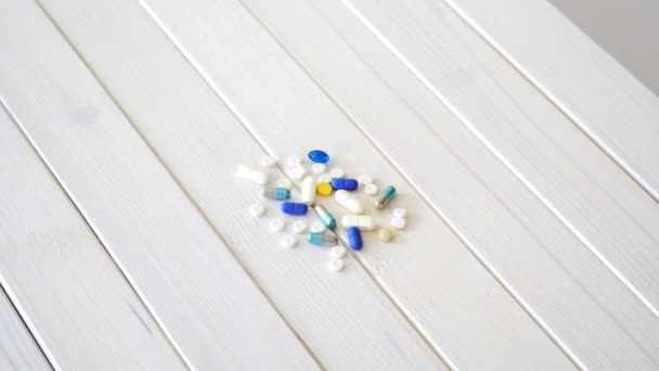 Uppsättning av olika piller på vitt bord — Stockvideo