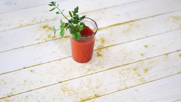 Saludable cóctel de tomate y vegano con ramita de perejil sobre mesa de madera blanca con arena — Vídeo de stock