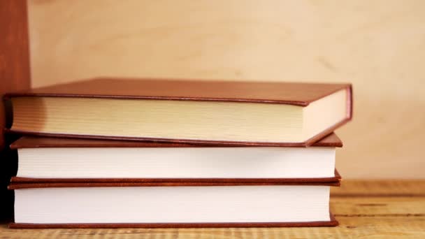 나무 선반에 가죽 커버에 오래 된 책 — 비디오