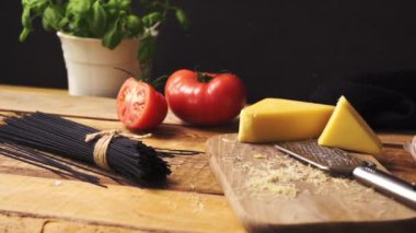 Ahşap mutfak masasında taze fesleğen ve İtalyan spagetti ile rendelenmiş peynir