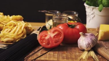 Ahşap mutfak masasında taze fesleğen ve İtalyan spagetti ile rendelenmiş peynir