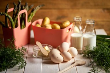 Beyaz mutfak masasında taze kuşkonus patates ve yumurta