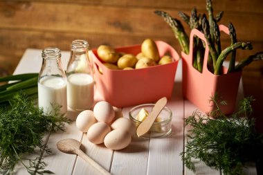 Beyaz mutfak masasında taze kuşkonus patates ve yumurta