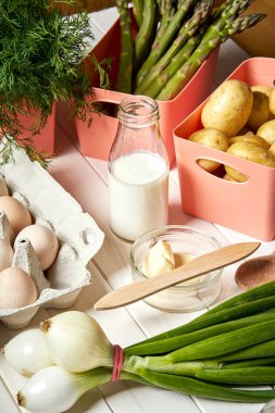 Beyaz mutfak masasında taze kuşkonus patates ve yumurta