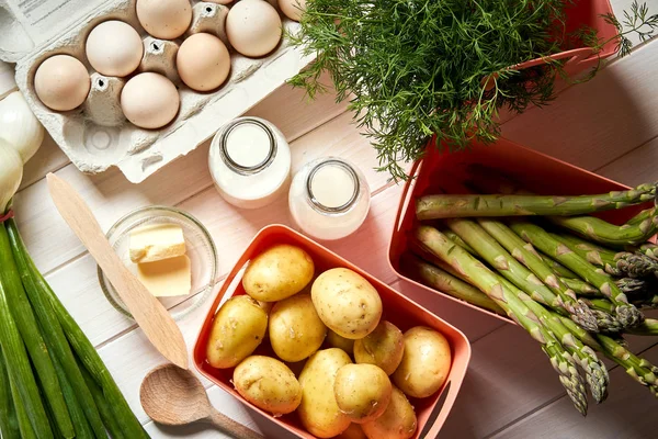 Свежая спаржа и яйца на белом кухонном столе — стоковое фото