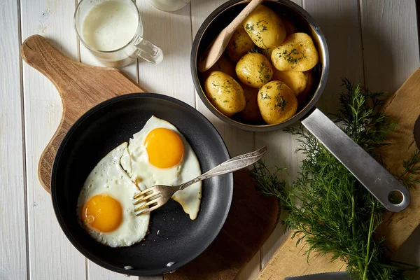 Spiegelei mit jungen Kartoffeln mit Dill und Milch auf Holztisch — Stockfoto
