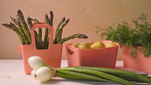Spring young vegetables in coral containers on wooden table — Stock Video