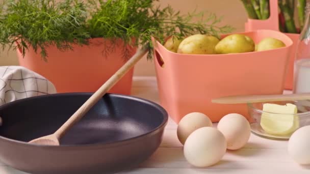 Verduras jóvenes de primavera con huevos y con leche y sartén sobre mesa de madera — Vídeos de Stock