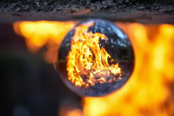 Vzhůru nohama přes lensball na rozmazaných táborním ohni v lese — Stock fotografie