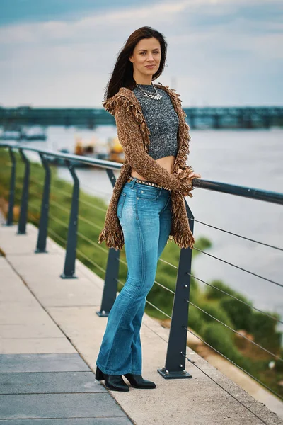 Красивая молодая женщина позирует на набережной у реки в городе — стоковое фото