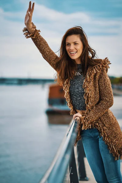 Красивая молодая женщина позирует на набережной у реки в городе — стоковое фото