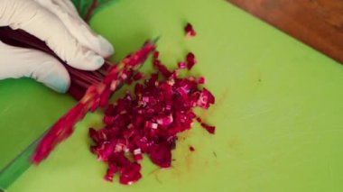 Ahşap masa üzerinde bebek pancar kesme eldiven kadın ellerin closeup