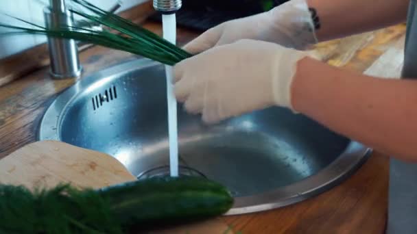 Vista de las manos femeninas en guantes lavados cebollino fresco en fregadero de cocina . — Vídeos de Stock