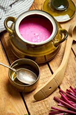 Rustik ahşap masa üzerinde soğuk pancar çorbası ve kaşık ile eski vazo