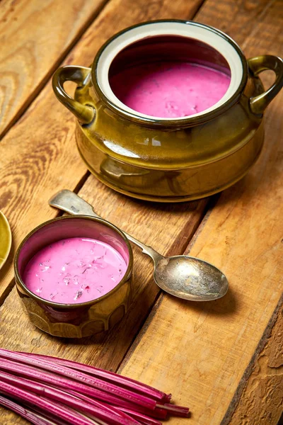 Vaso vecchio con zuppa fredda di barbabietole e cucchiaio su un tavolo di legno rustico — Foto Stock