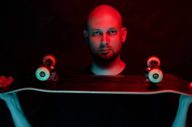 Neon ışık arka planda kaykay ile siyah gömlek Skateboarder