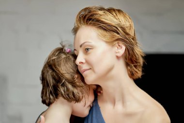 Güzel küçük kızı ile anne poz içinde stüdyo üzerinde gri arka plan