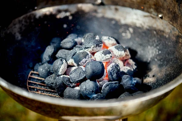 Gros plan de charbon rougeoyant dans la grille métallique le jour de l'été dans le jardin — Photo