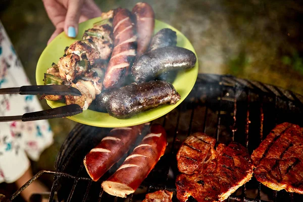 Sappige worstjes rechtstreeks van Grill op groene plaat van hete barbecue — Stockfoto