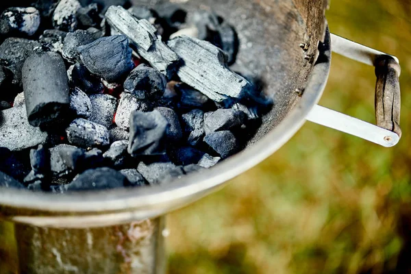 Крупный план светящегося угля в металлическом гриле в летний день в саду — стоковое фото