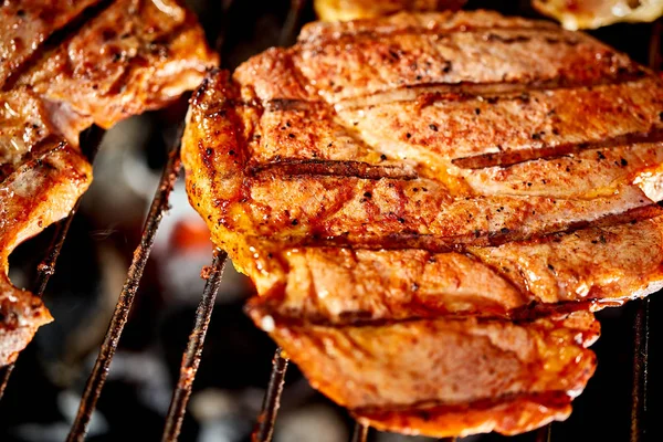 Bifes de carne suculentos na grelha com chama no churrasco no jardim — Fotografia de Stock