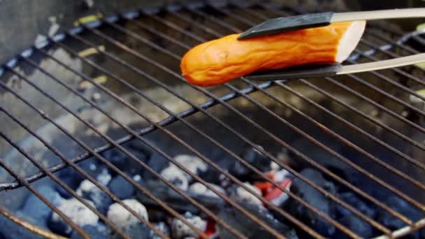 Сочная колбаса на горячем гриле во время летнего барбекю в замедленной съемке — стоковое видео