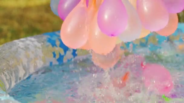 Primer plano de globos de agua de colores llenos de agua en el día de verano — Vídeo de stock